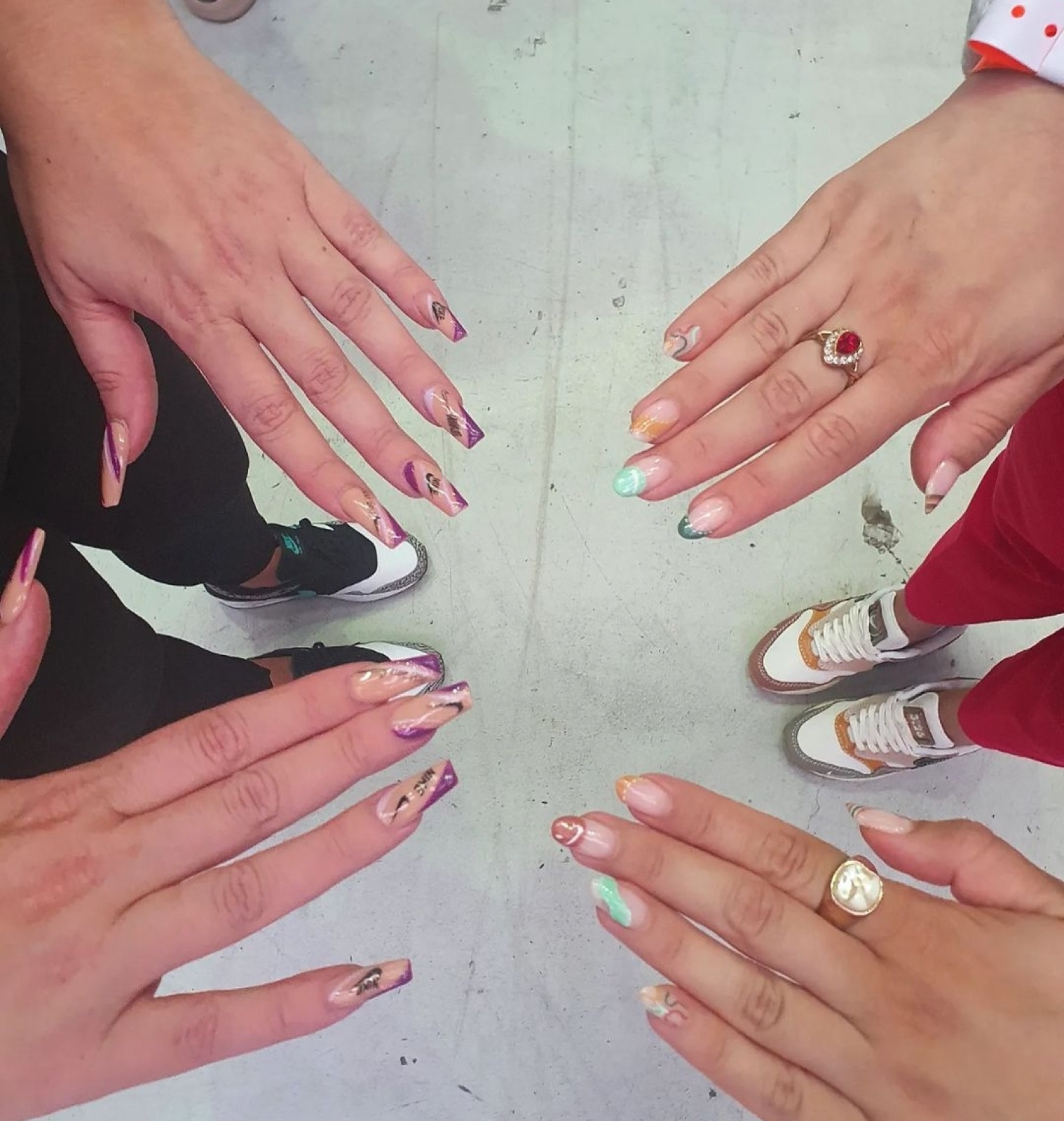 Vier handen met verschillende nail art designs